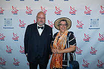Sebastian von Bomhard und eine Frau stehen vor einer Wand, auf der mehrere SpaceNet Award-Logos zu sehen sind