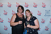 Vor einer weißen Wand mit mehreren SpaceNet Awards-Logos stehen zwei Frauen