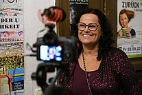 Eine Frau mit Brille wird interviewt