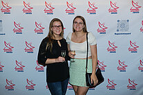 Vor einer weißen Wand mit mehreren SpaceNet Awards-Logos stehen zwei Frauen