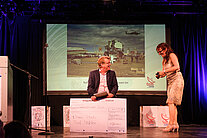 Katja Holzer steht mit dem Gewinner des SpaceNet Awards auf der Bühne