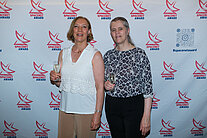 Vor einer weißen Wand mit mehreren SpaceNet Awards-Logos stehen zwei Frauen
