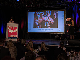 Auf einer Bühne wird der erste Platz des SpaceNet Awards vor einem Publikum präsentiert