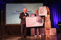 Sebastian Von Bomhard übergibt den Preis an den Gewinner des SpaceNet Awards auf der Bühne