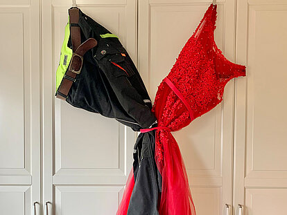 Zusammengebundene Hose und Kleid hängen an einem weißen Schrank
