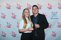 Vor einer weißen Wand mit mehreren SpaceNet Awards-Logos stehen ein Mann und eine Frau